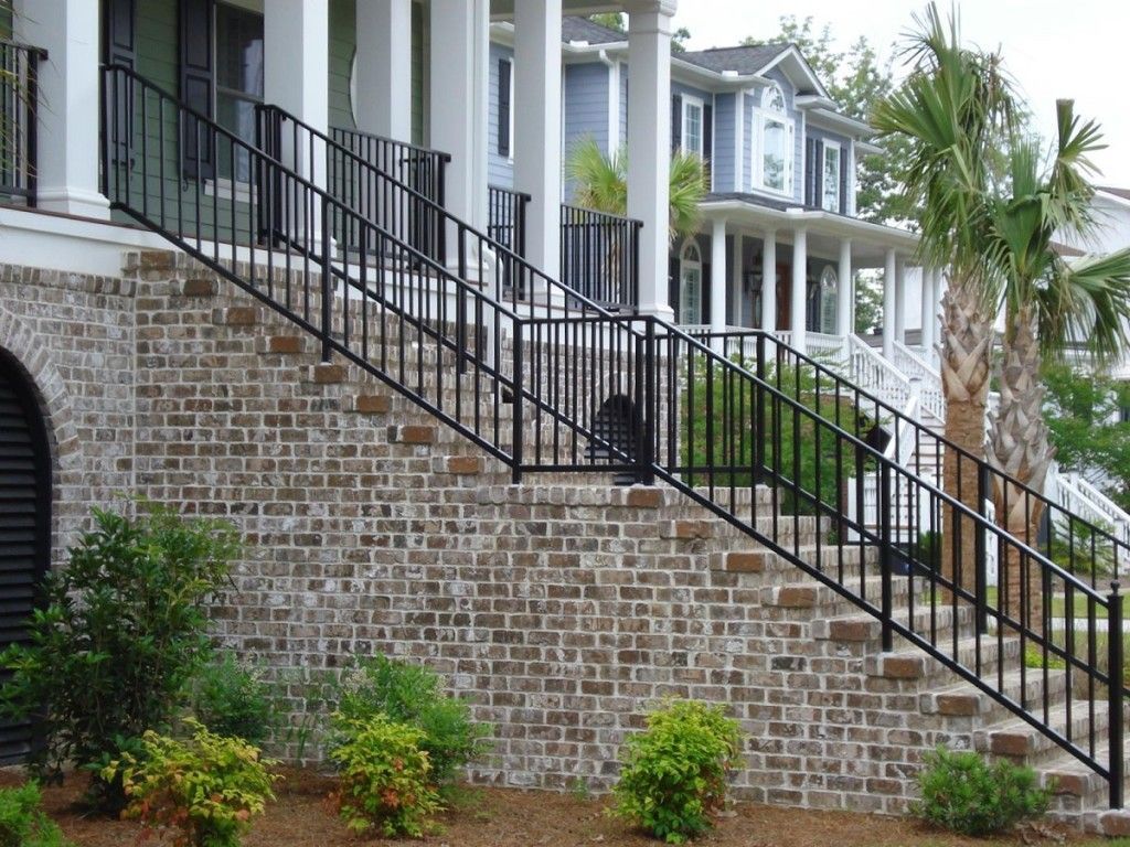 A brick wall with stairs leading up to a house