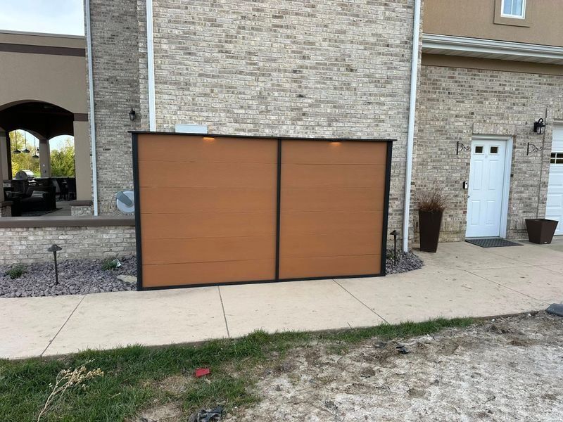 Two-car garage doors on a brick building beside a sidewalk and front door