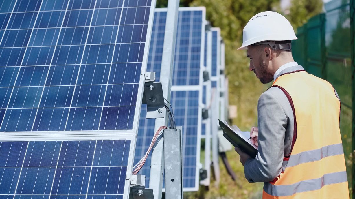 Un uomo sta pulendo un pannello solare con una spazzola.