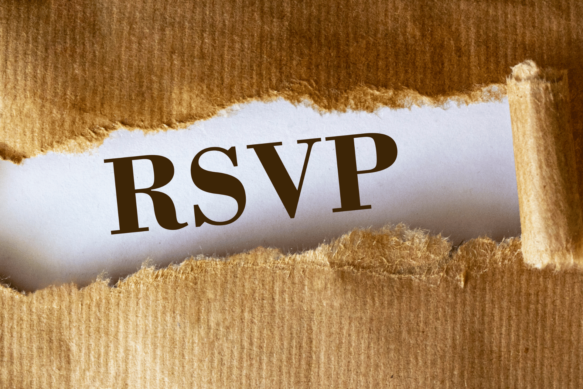 A piece of torn paper with the word rsvp written on it