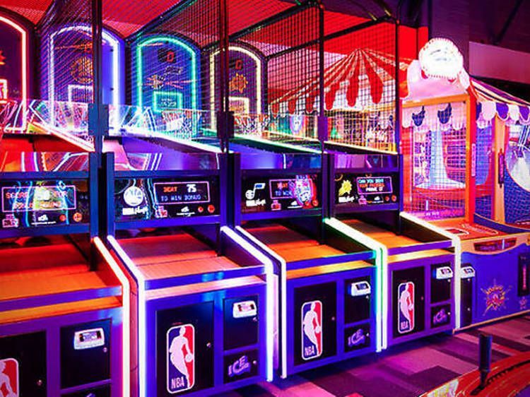 A bunch of arcade games are lined up in a room.