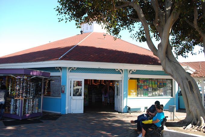 A blue building with a red roof and a tree in front of it