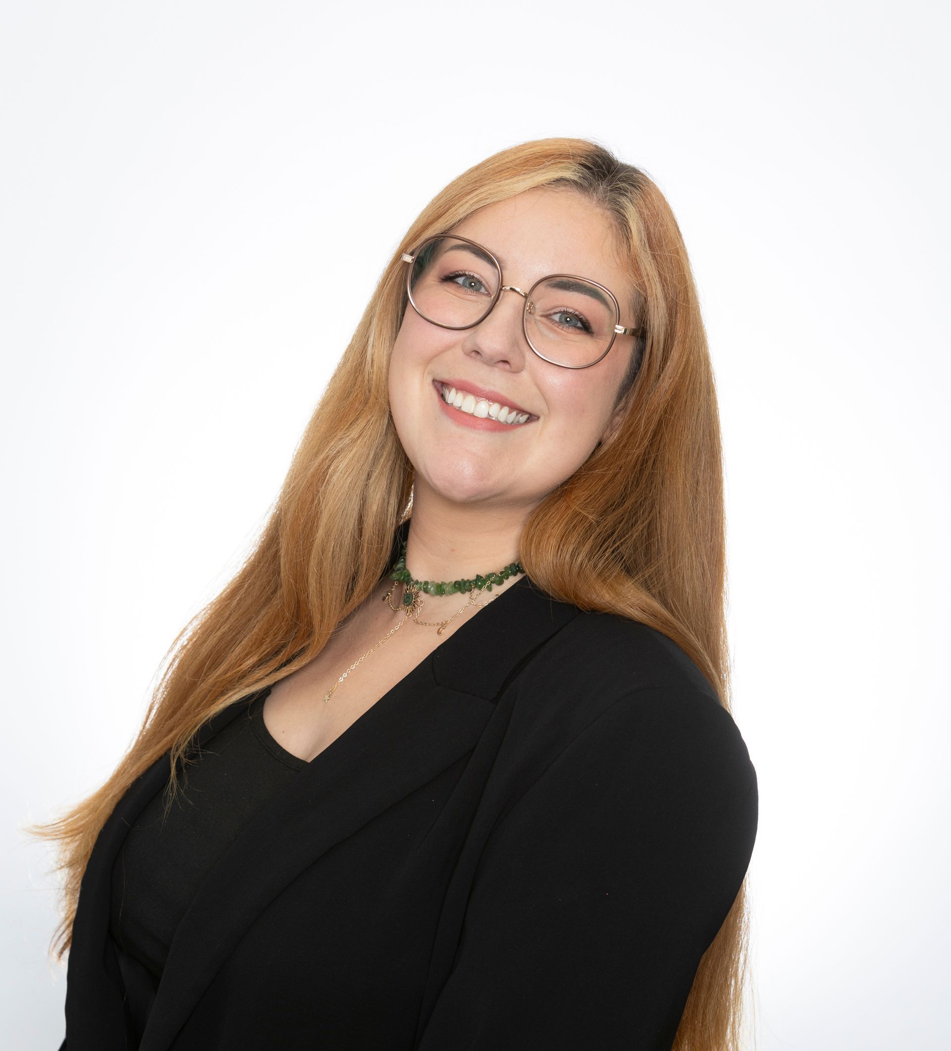 A woman wearing glasses and a black shirt is smiling for the camera.