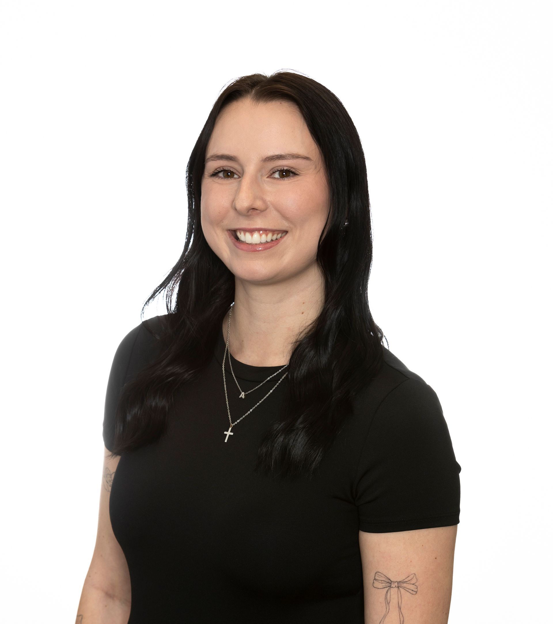 A woman wearing glasses and a black shirt is smiling for the camera.