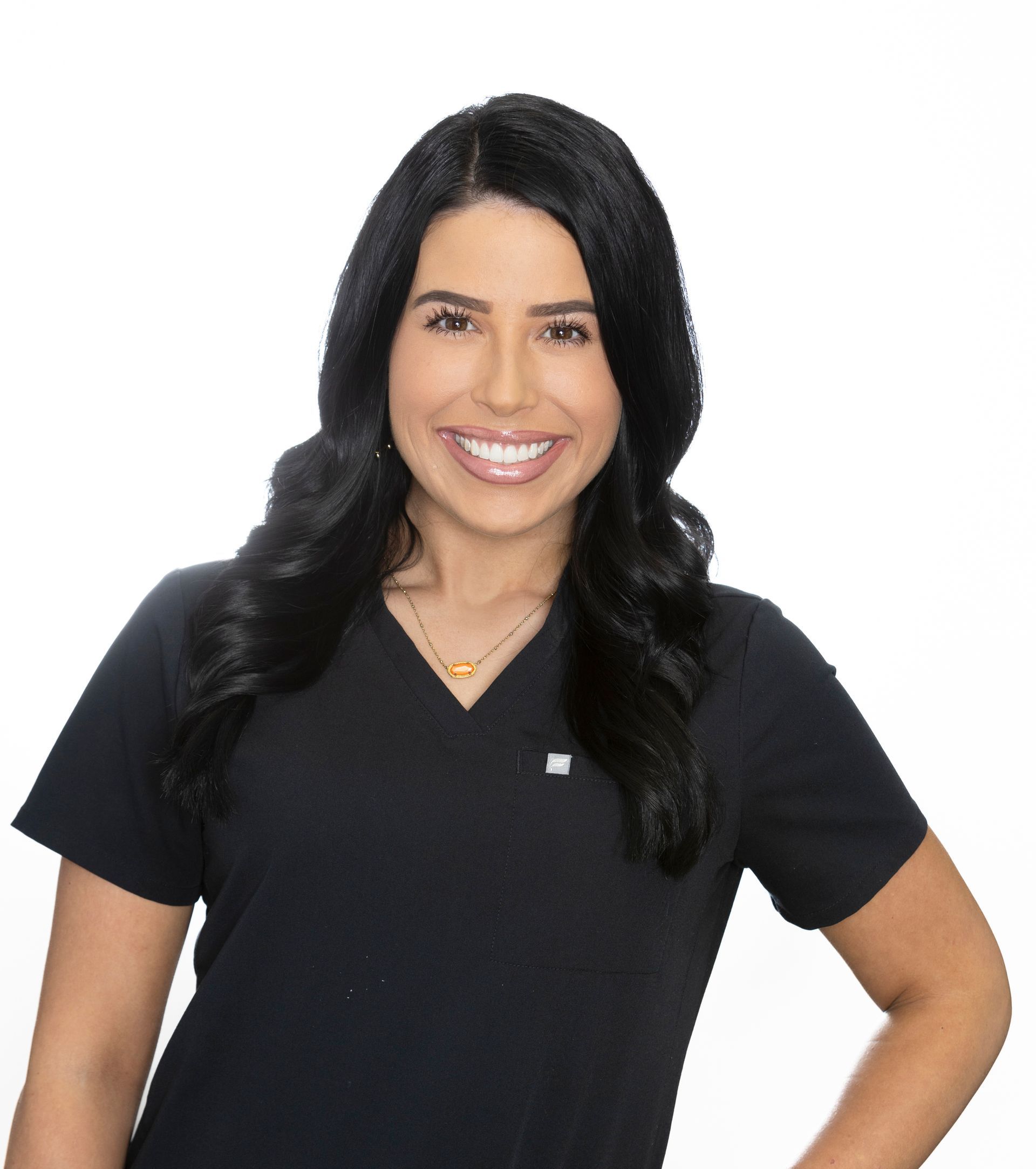 A woman in a blue scrub top is smiling for the camera