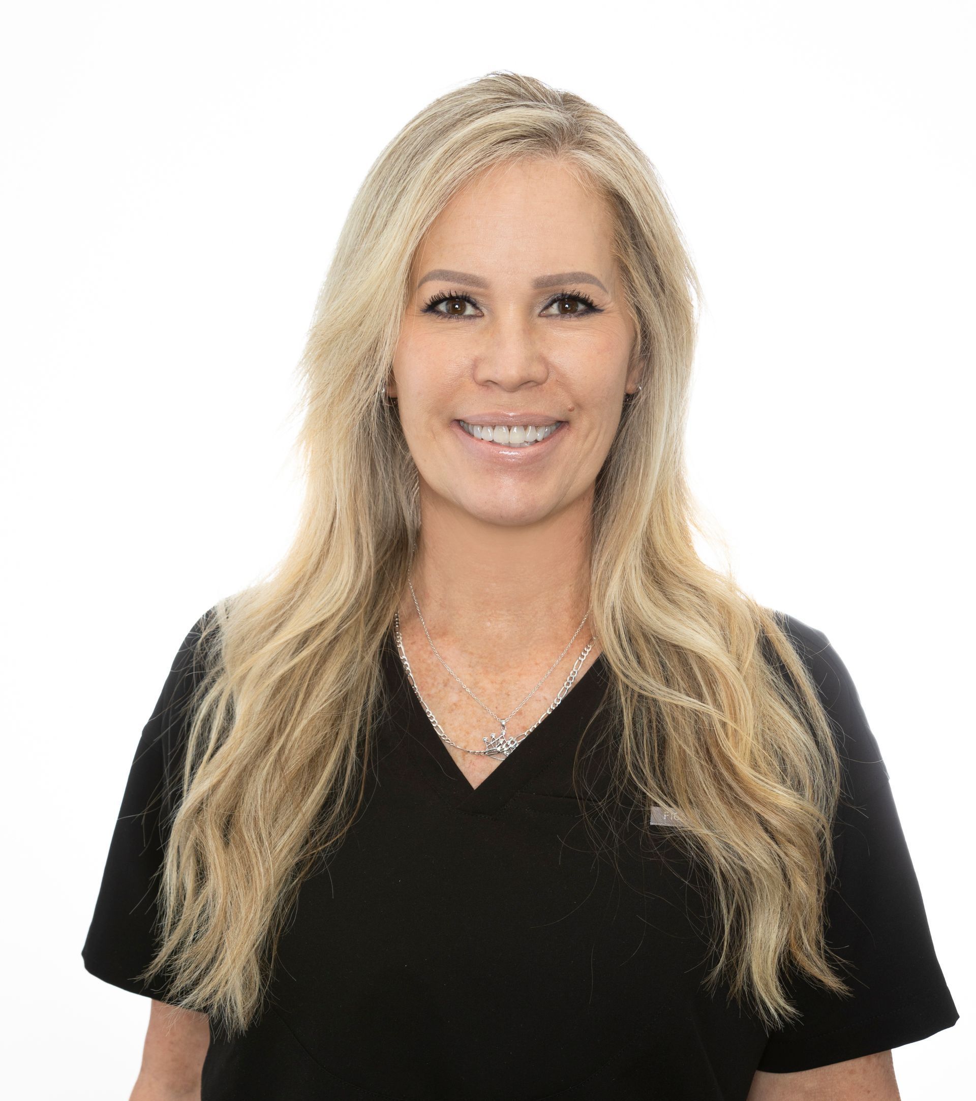 A woman wearing glasses and a black shirt is smiling for the camera.