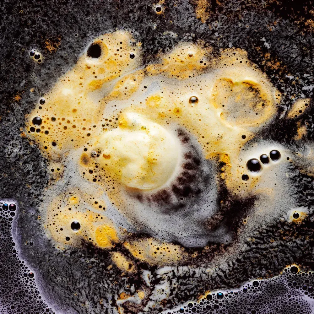 A close up of a brown liquid with bubbles in it.