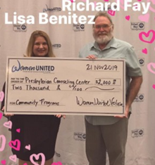 A man and a woman are holding a check for $ 2,000.