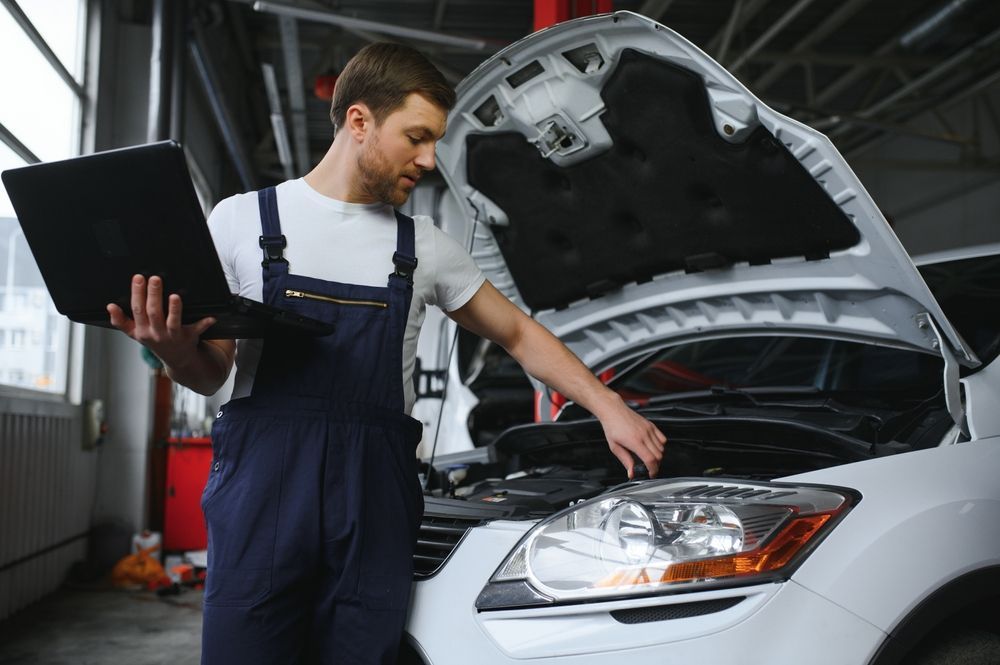Mechanic Using a Laptop, Inspecting a Car Engine in a Garage — Ryder's Garage In Kincumber, NSW