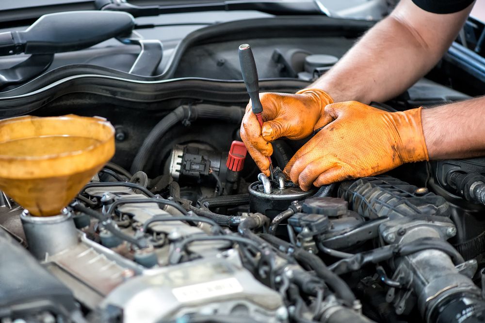 Mechanic Wearing Orange Gloves Working on A Car Engine — Ryder's Garage in Bensville, NSW