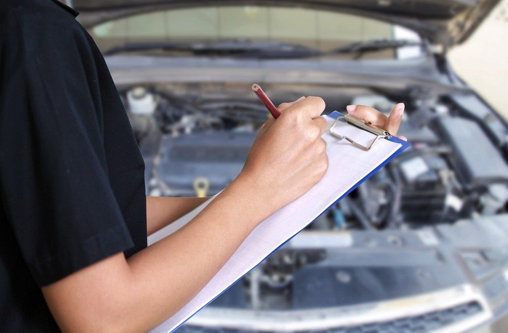 Mechanic Writing on Clipboard While Inspecting a Car Engine — Ryder's Garage in Saratoga, NSW