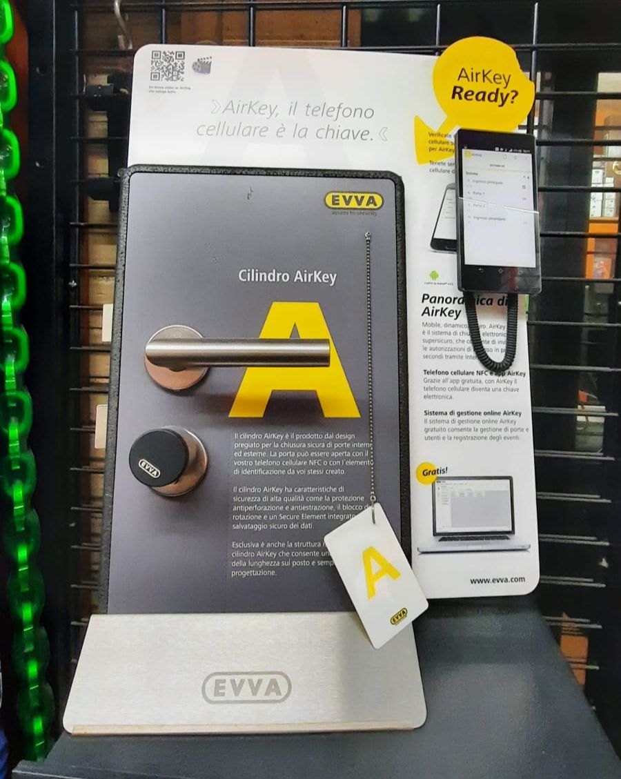 Espositore per stazione di ricarica per veicoli elettrici con pannello grigio, dettagli gialli e cavo di ricarica in una vetrina.