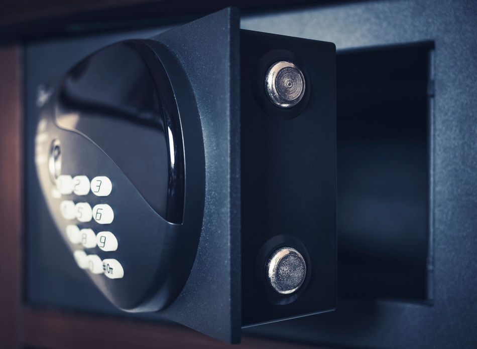 Sportello di cassaforte elettronica nero con tastiera e chiavistelli argentati, vista ravvicinata.