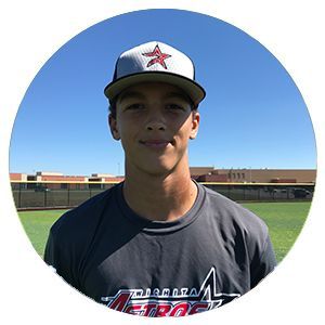 Portrait of a baseball player in a cap and team shirt on a field under a clear blue sky