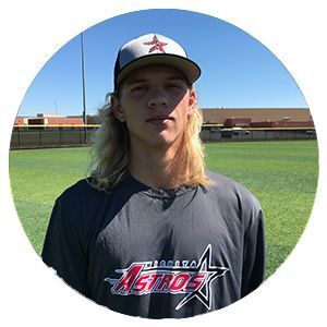 Baseball player in Houston Astros jersey and cap standing on a field under a blue sky