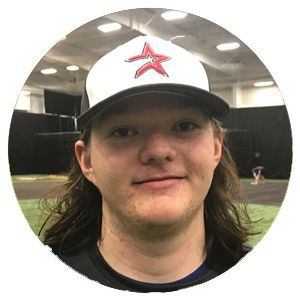 Person wearing a white cap with a red star in an indoor sports facility, looking at the camera.