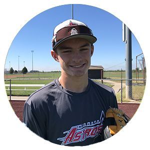 Smiling baseball player in Astros shirt holding a glove on a field