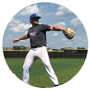 Baseball player in gray and white uniform preparing to throw on a field