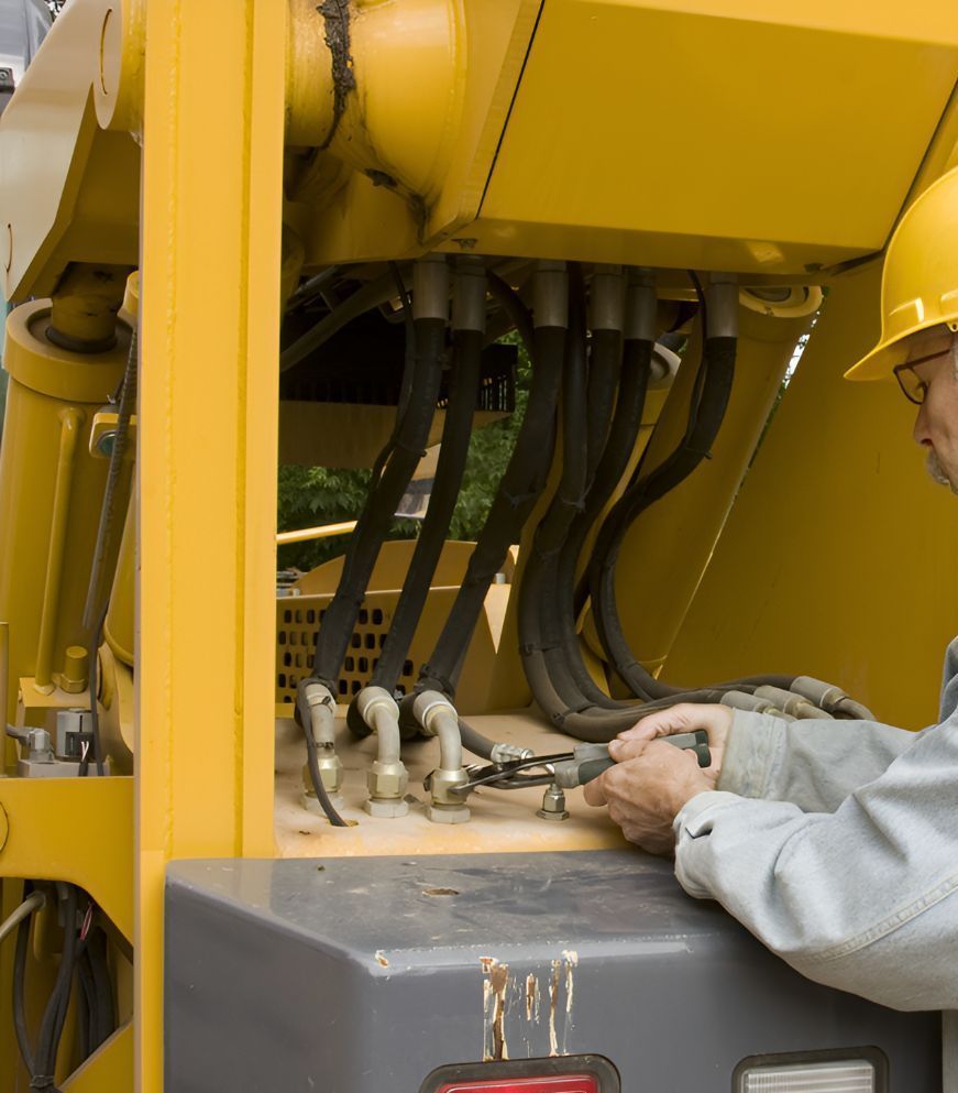 A Man Wearing a Hard Hat is Working on a Yellow Machine — North Coast Construction Equipment In Grafton, NSW