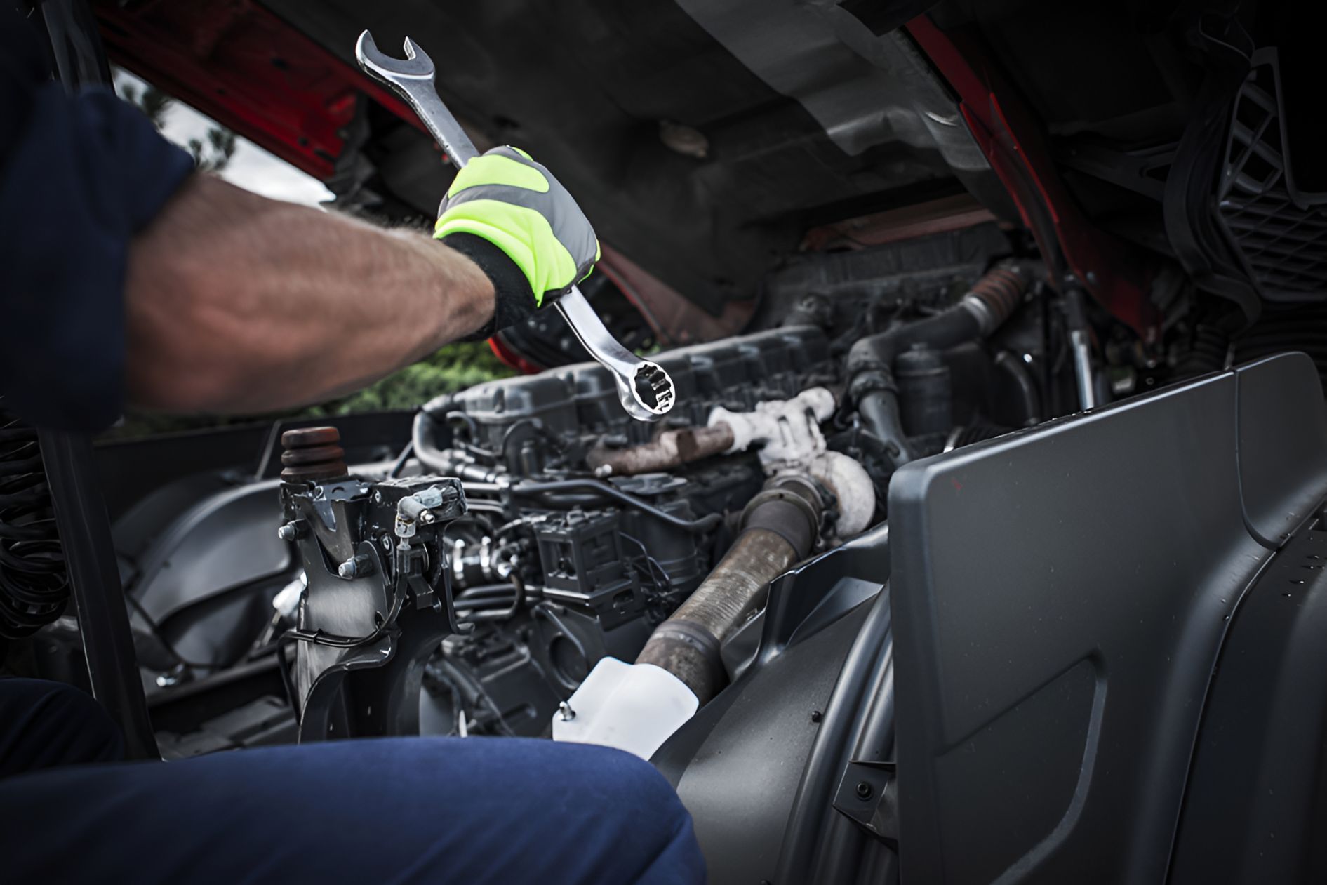A Man is Working on a Truck Engine With a Wrench — North Coast Construction Equipment In Grafton, NSW