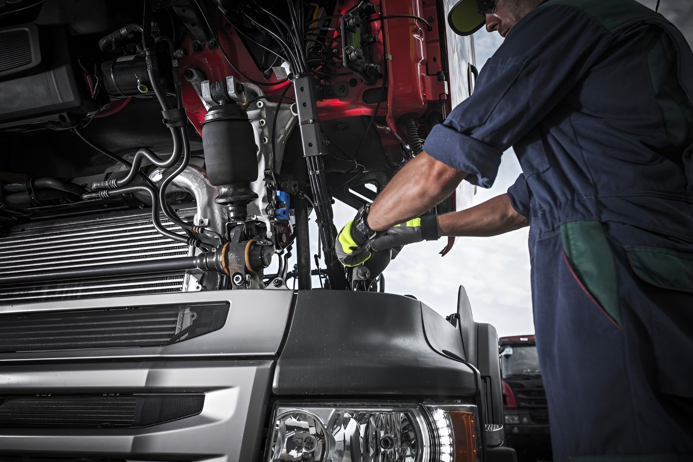 Man is Working on the Engine of a Truck — North Coast Construction Equipment In Nambucca Heads, NSW
