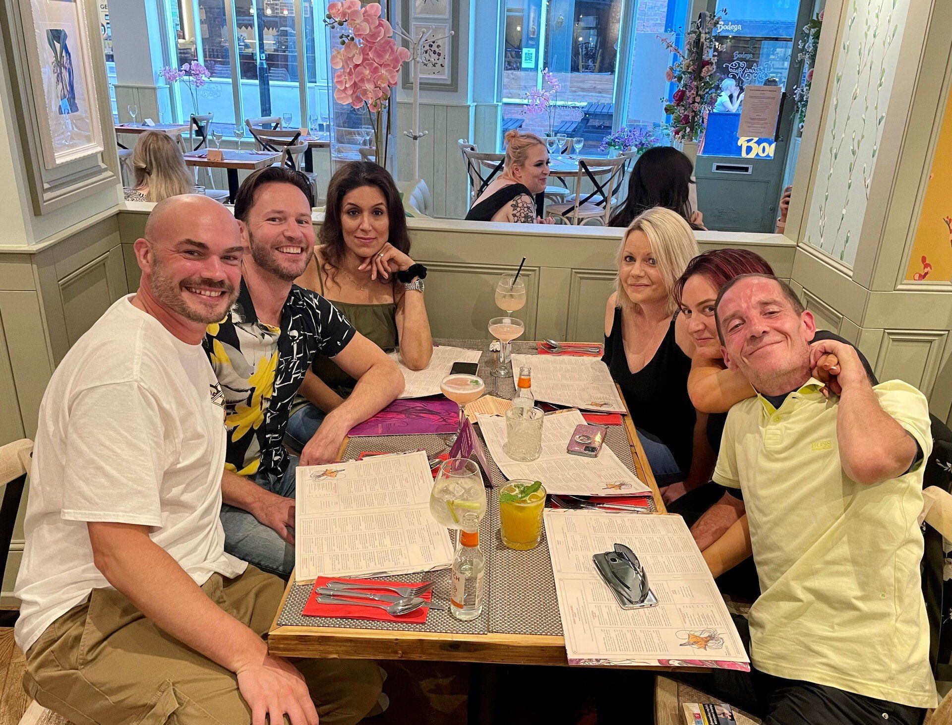 A group of people are sitting around a table in a restaurant.