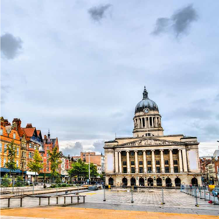 A large building with a dome on top of it is in the middle of a city.