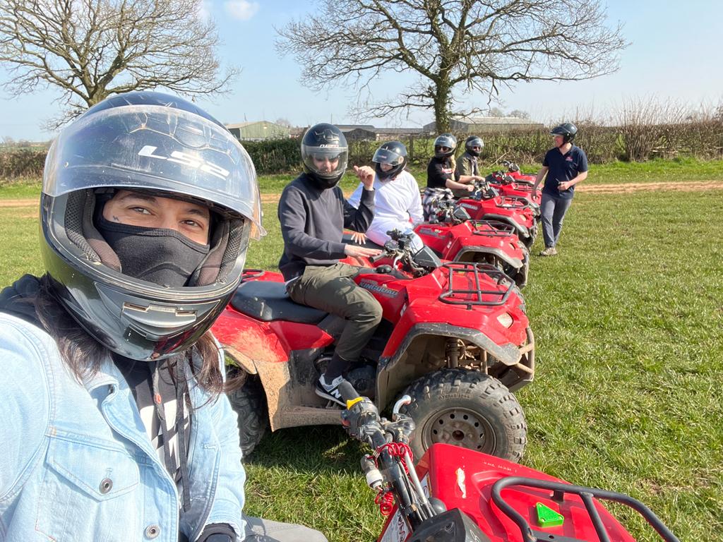 A group of people are riding atvs in a field.