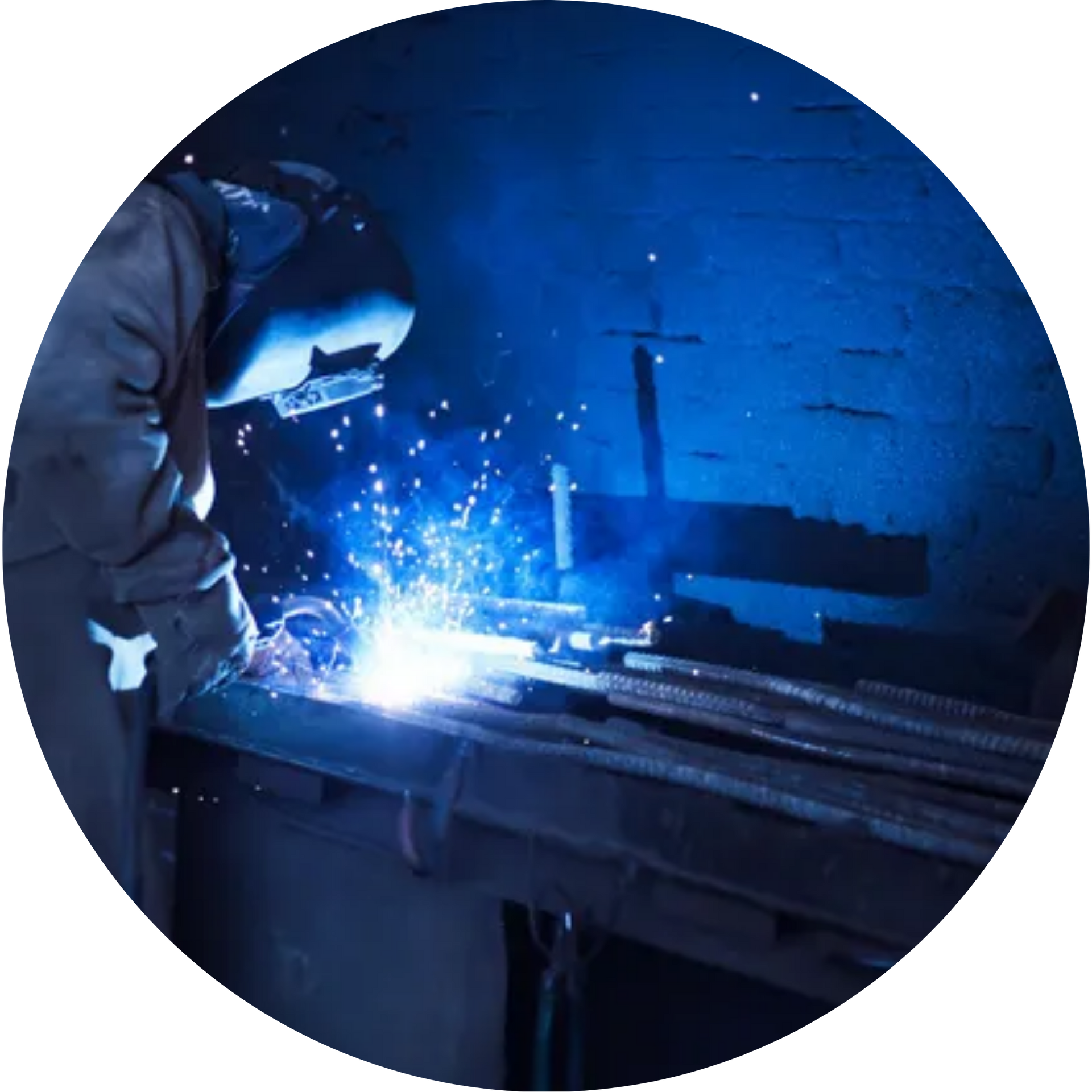 A man is welding a piece of metal in a dark room.