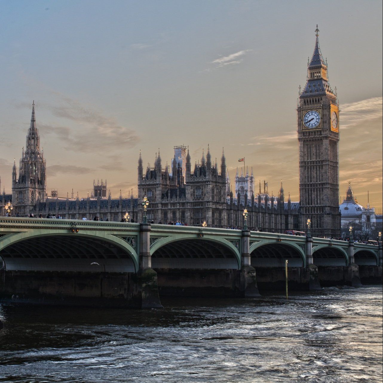 A bridge over a river with big ben in the background