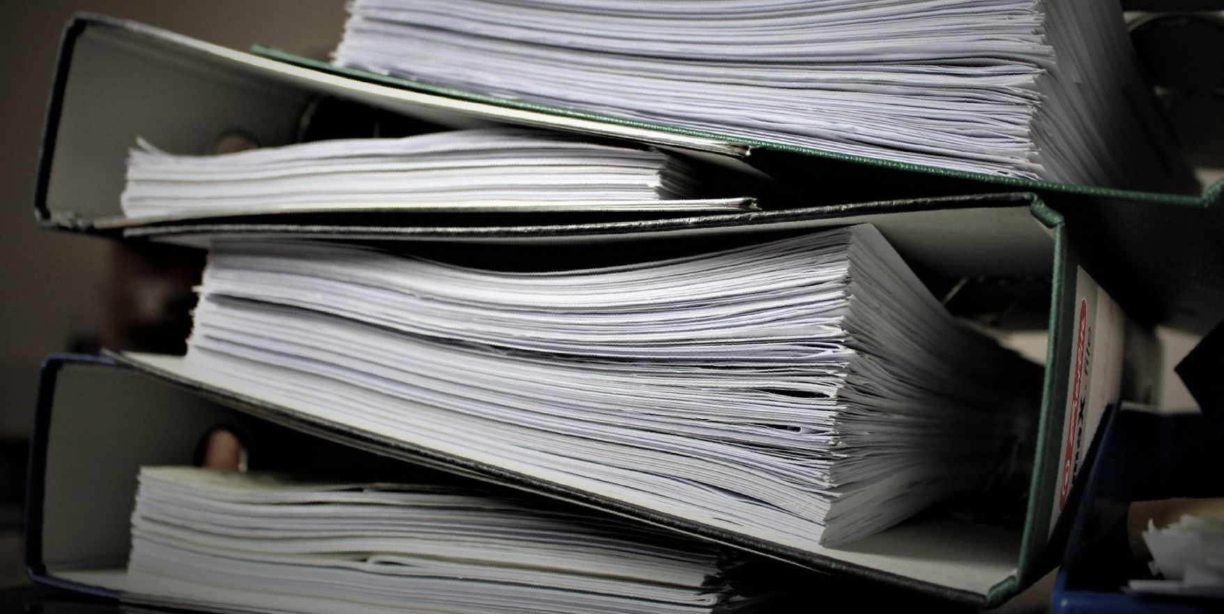 A pile of binders stacked on top of each other.