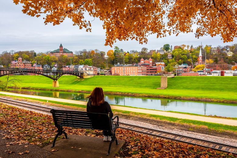woman sitting on a park bench overlooking Galena in the fall