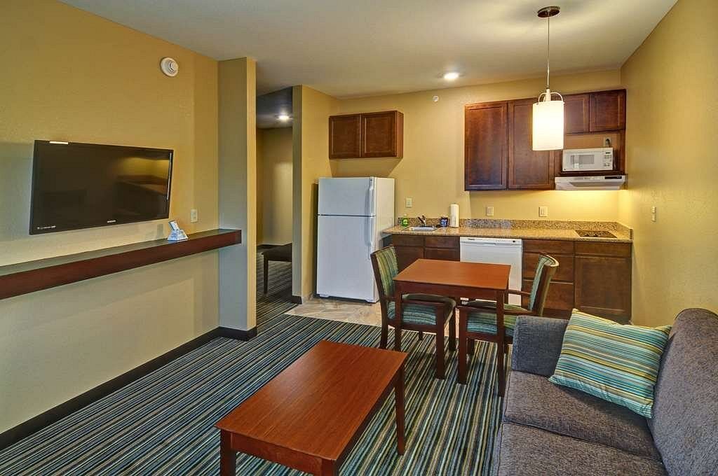 A hotel room with a couch , table and television