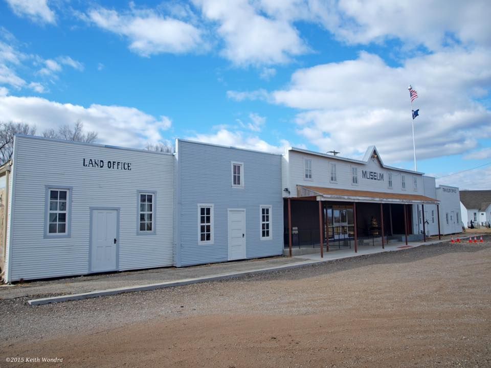 A row of old west style buildings with one that says land office on it