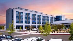 Sierra Medical Center building with a parking lot and trees; sunset sky.