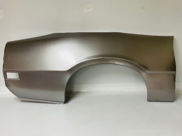 A bare metal car quarter panel with a wheel well and a tail light opening, against a white background.