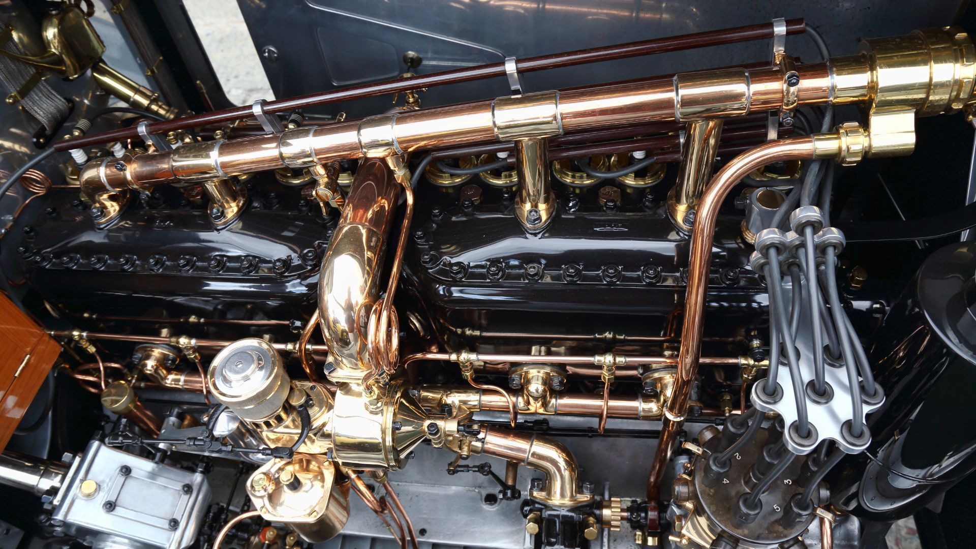 Polished brass saxophone keys and mechanism in close-up against a dark glossy background