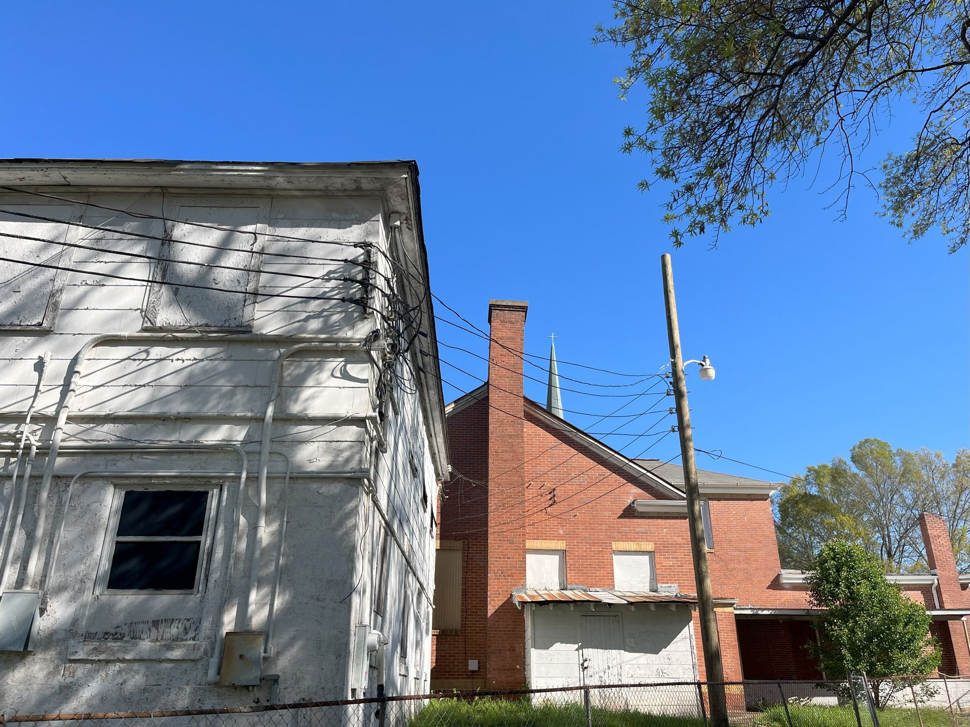 A brick building with a chimney next to a white building