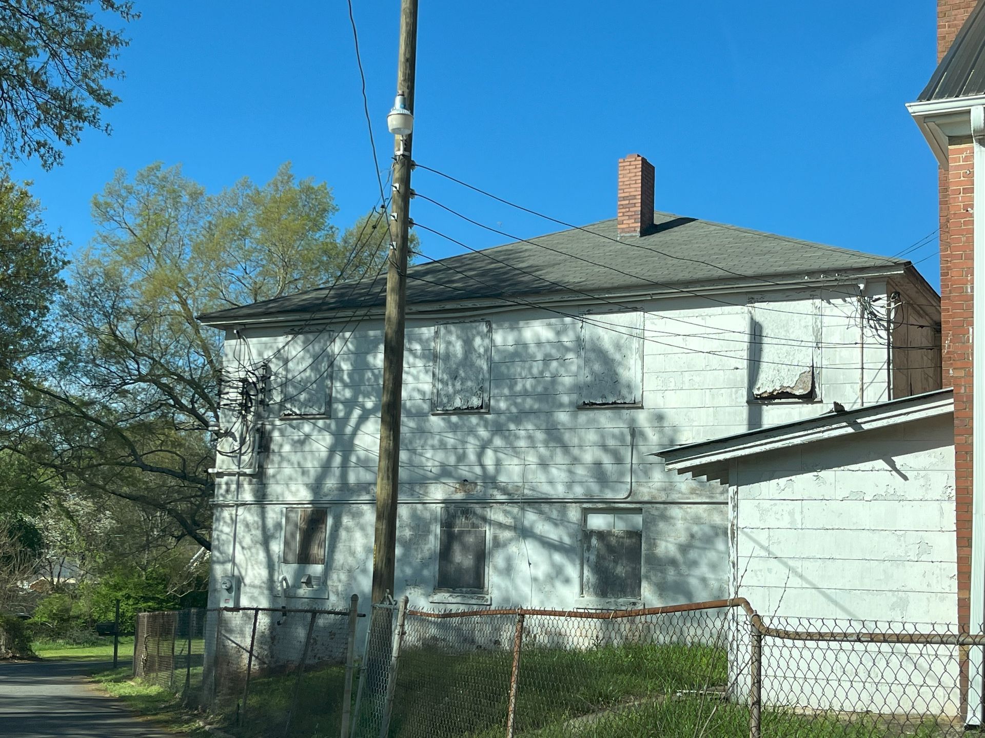 An old white house with a chimney on the roof