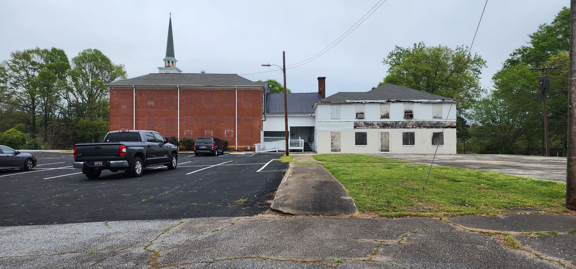 A truck is driving down a road in front of a church.