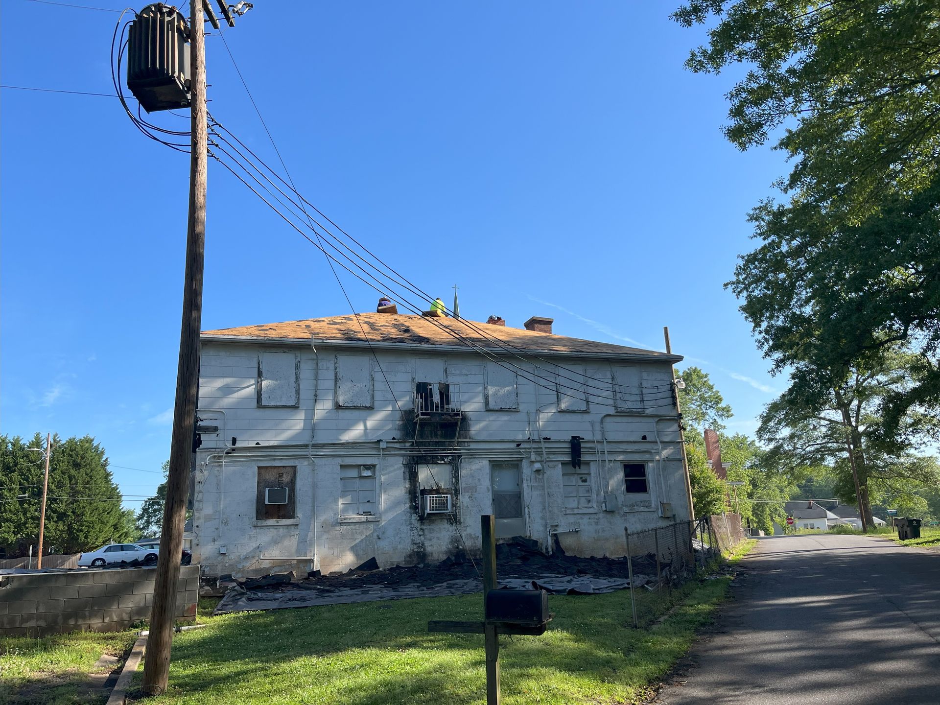 A white building with a telephone pole in front of it
