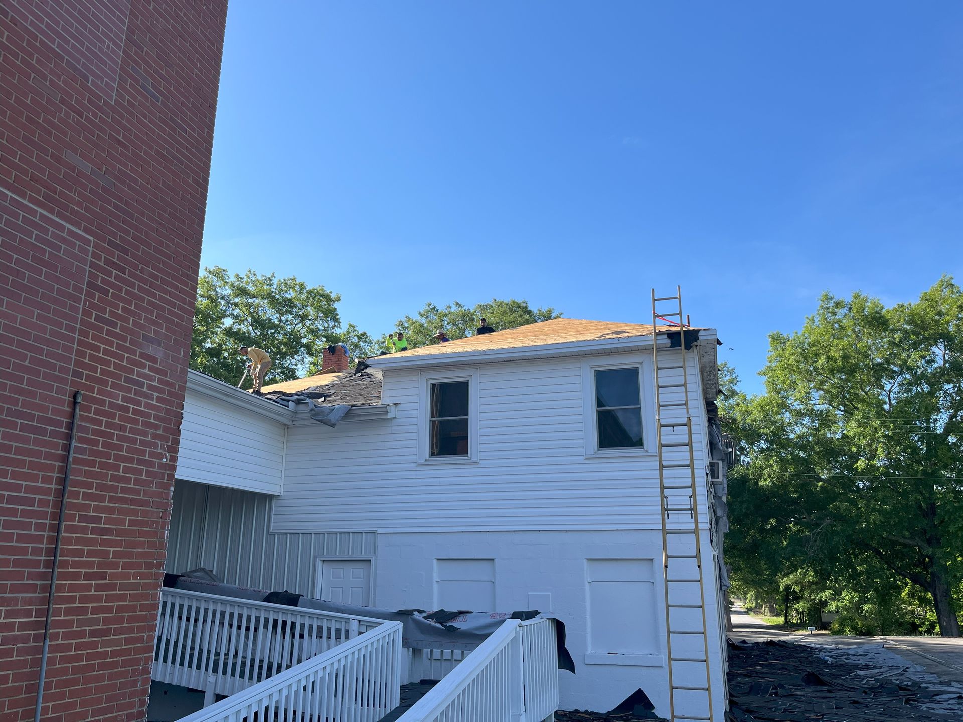 A white house with a ladder on the side of it.