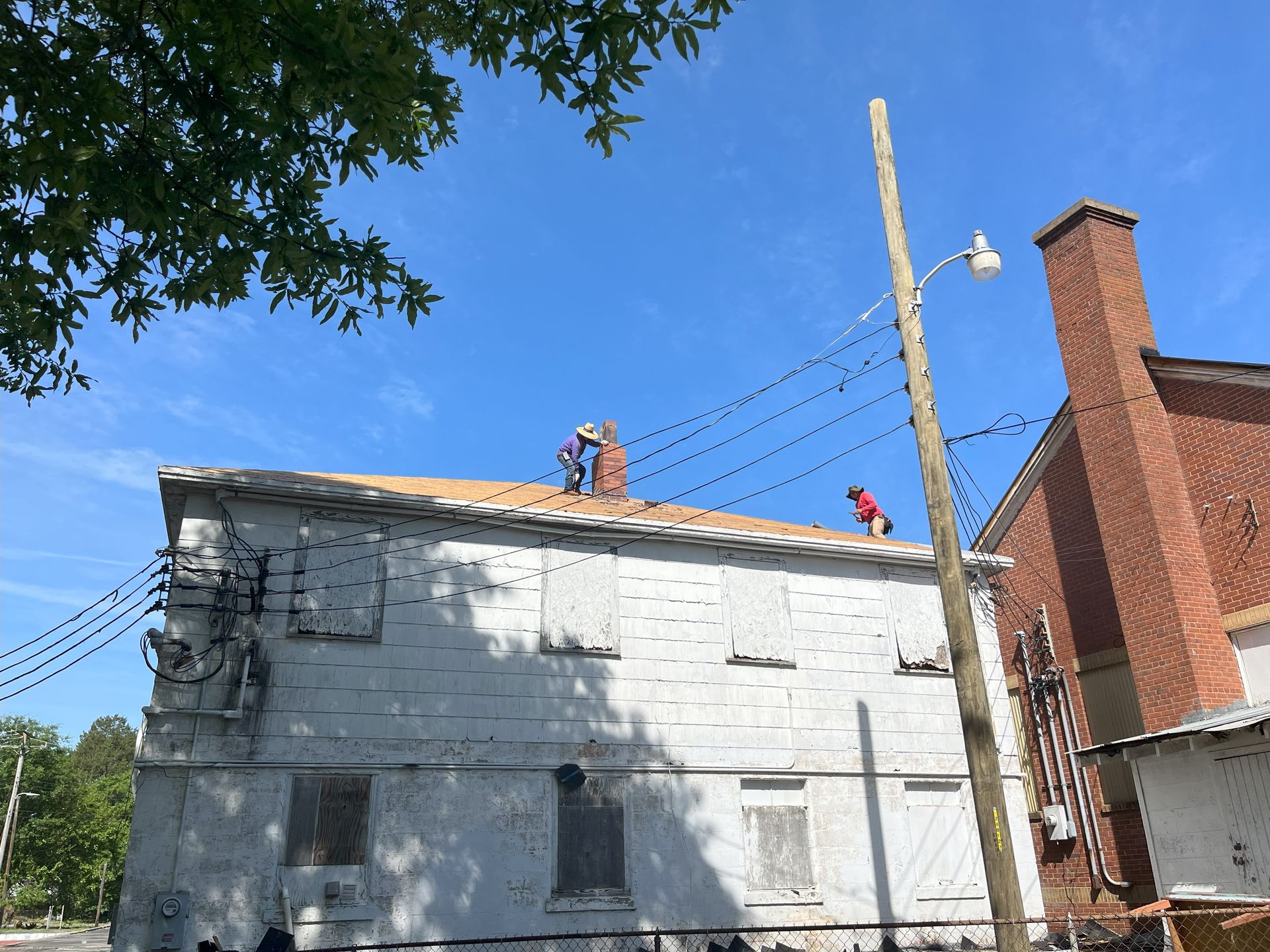 Two men are working on the roof of a building.