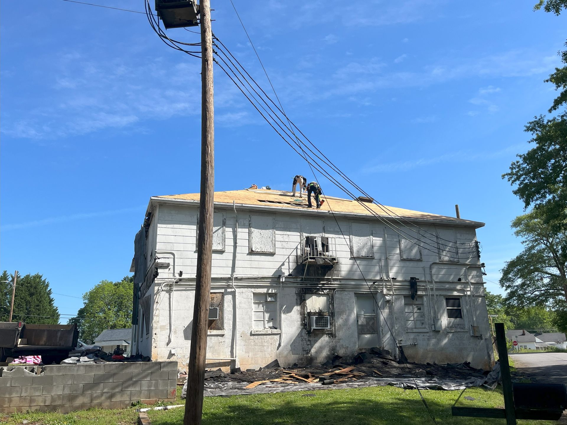 A large white building with a roof that is being remodeled.