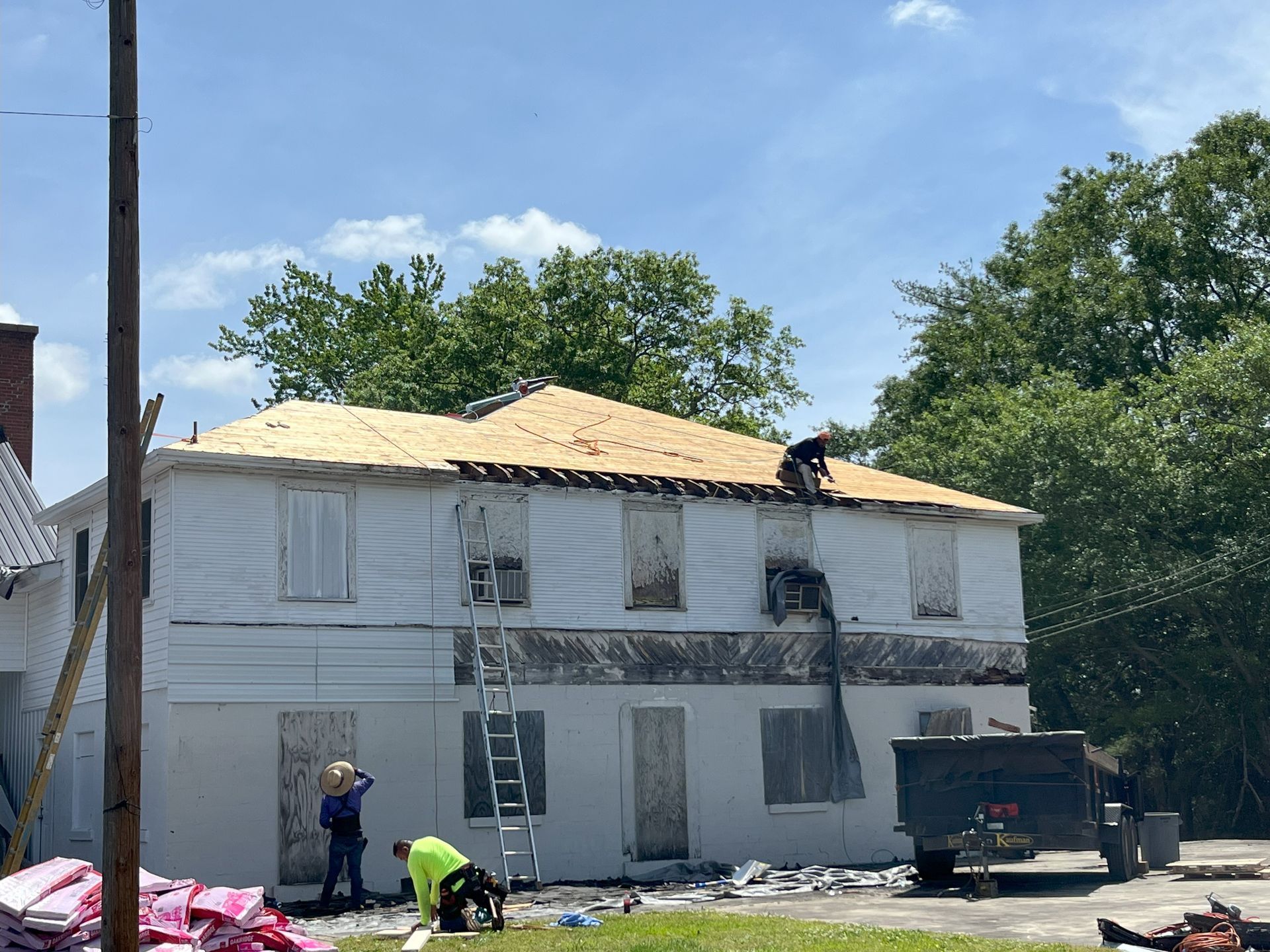A group of people are working on the roof of a house.