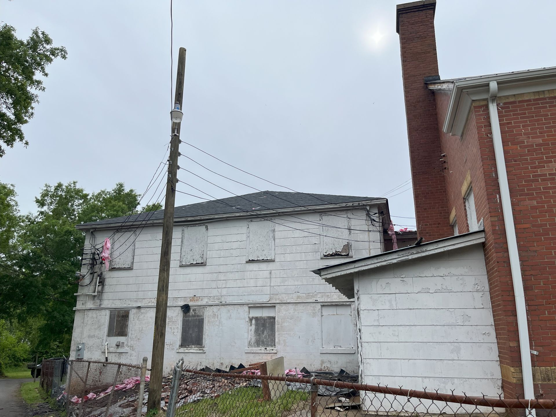 A brick building with a chimney next to a white building