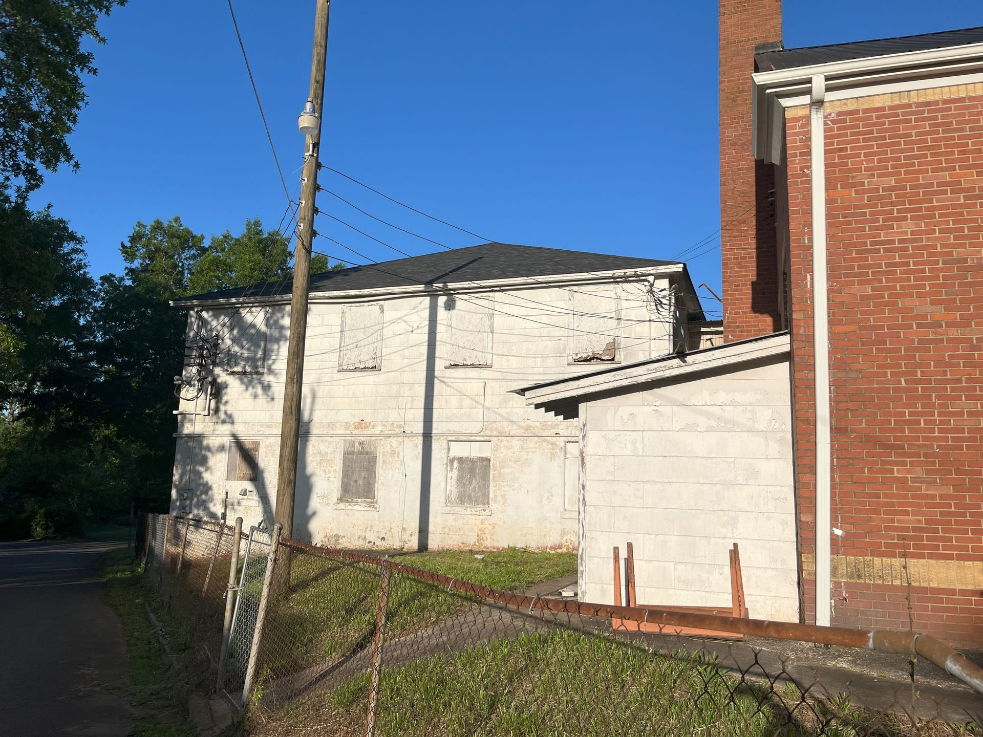 A white building with a red brick building in the background.