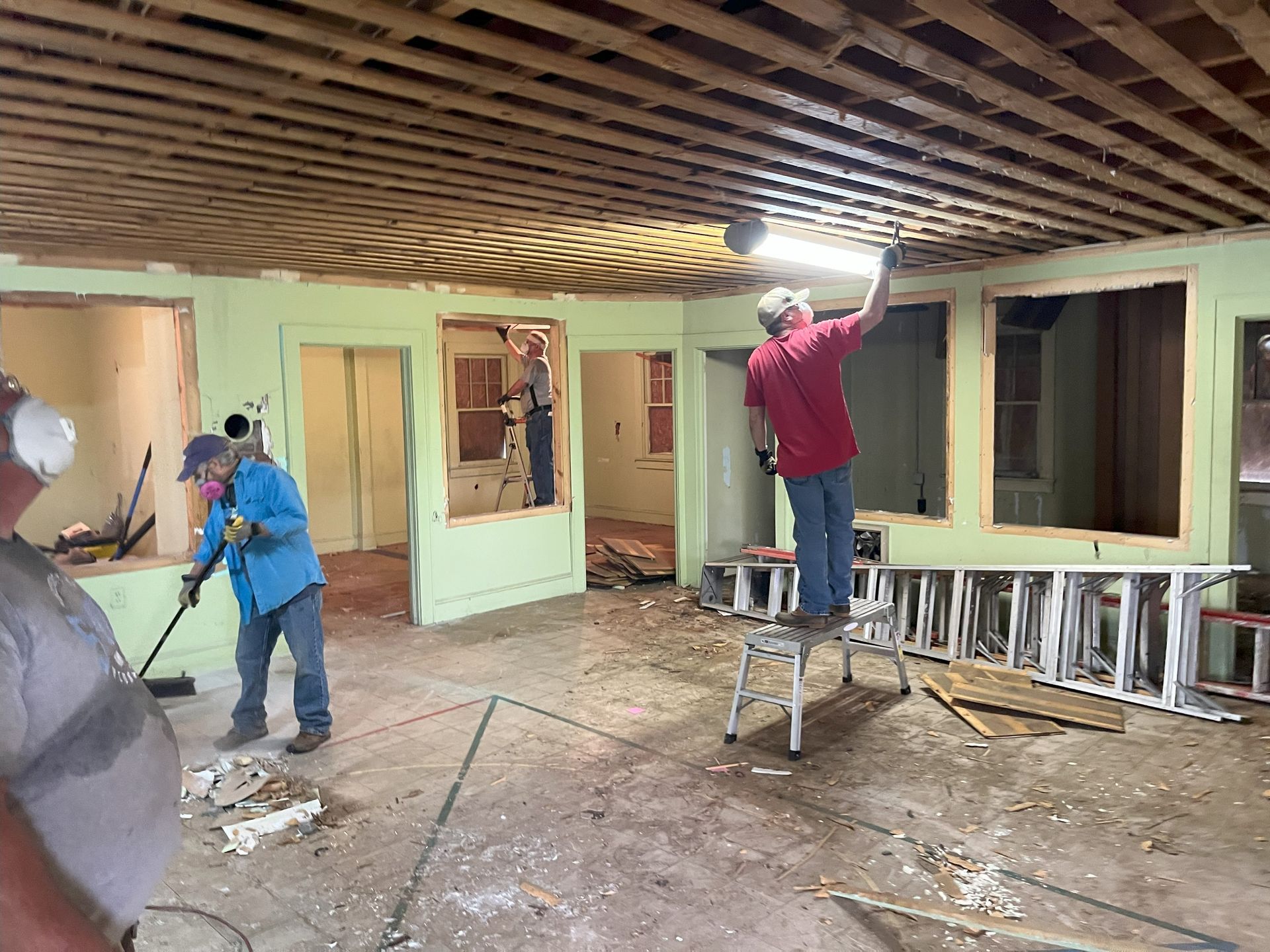 A group of people are working on a house.