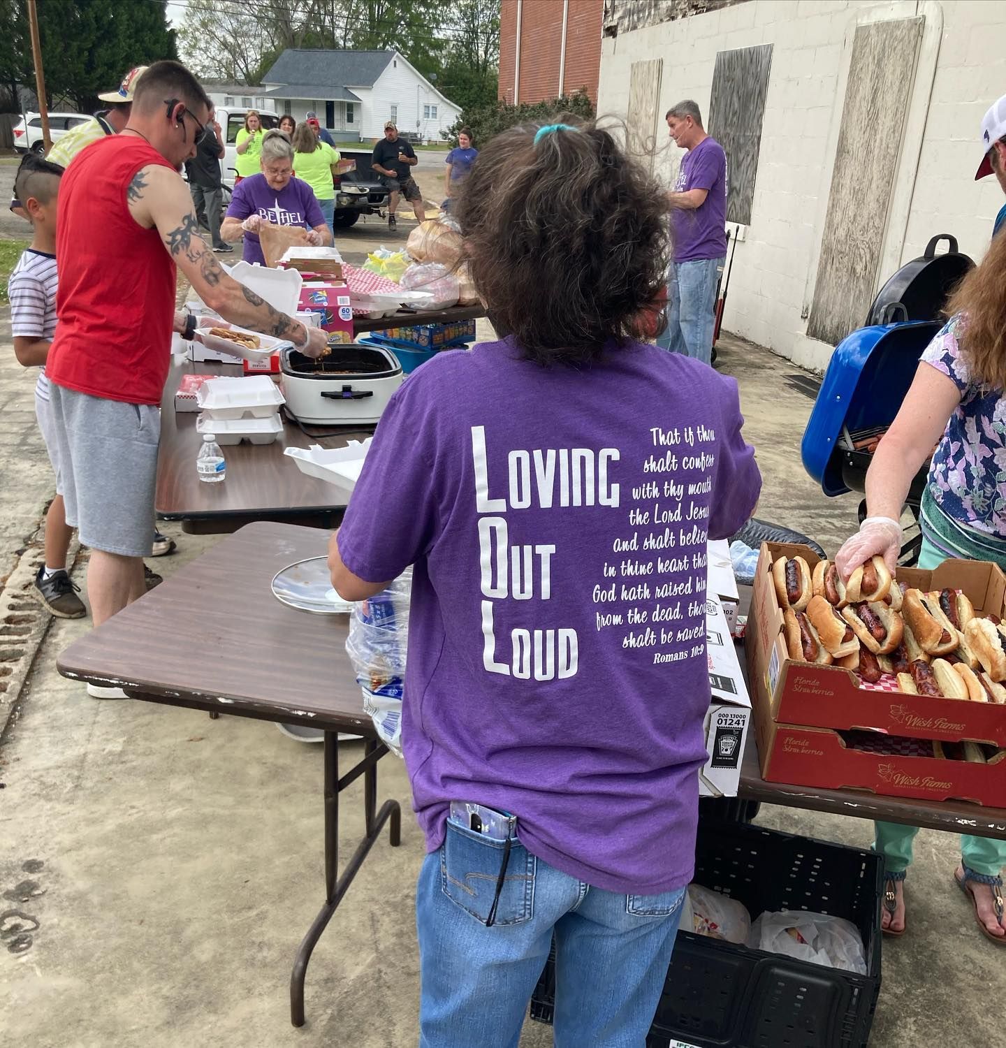 A woman wearing a purple shirt that says loving but loud