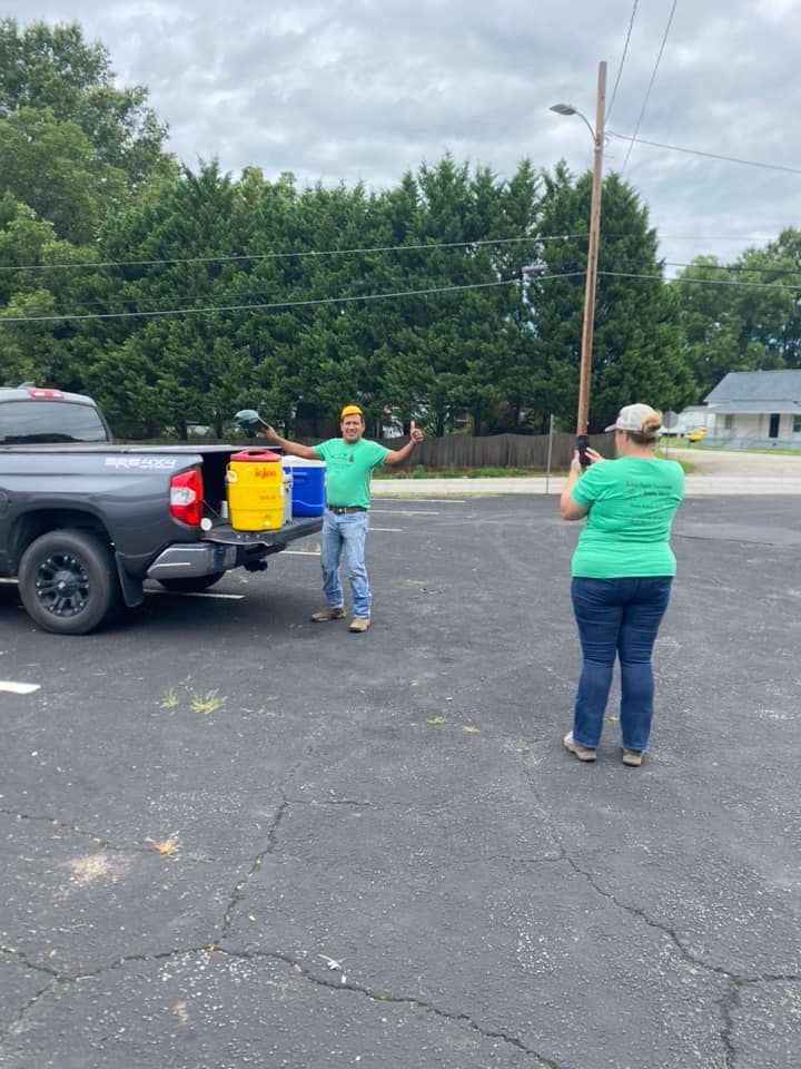 A man and a woman are standing in front of a truck in a parking lot.